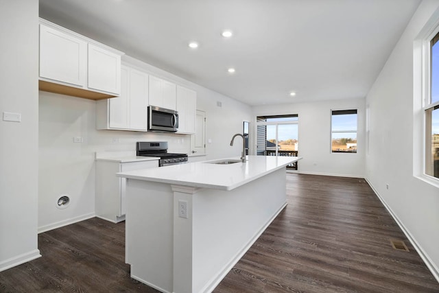 kitchen featuring sink, dark hardwood / wood-style floors, an island with sink, white cabinetry, and stainless steel appliances