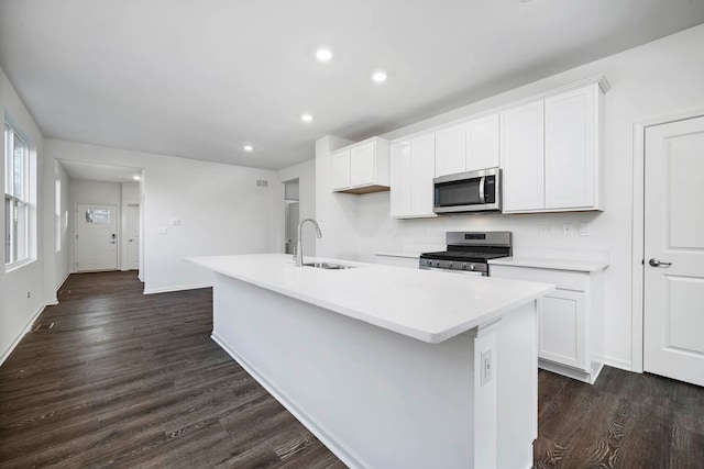 kitchen featuring a kitchen island with sink, sink, dark hardwood / wood-style floors, appliances with stainless steel finishes, and white cabinetry