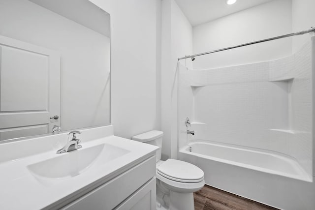 full bathroom with hardwood / wood-style floors, vanity, toilet, and shower / washtub combination