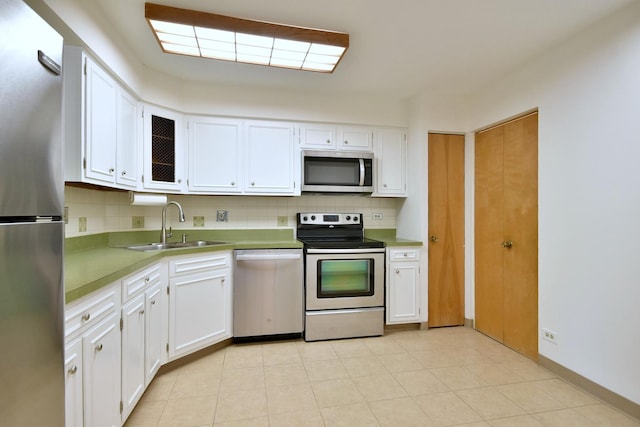 kitchen featuring stainless steel appliances, white cabinetry, sink, and tasteful backsplash