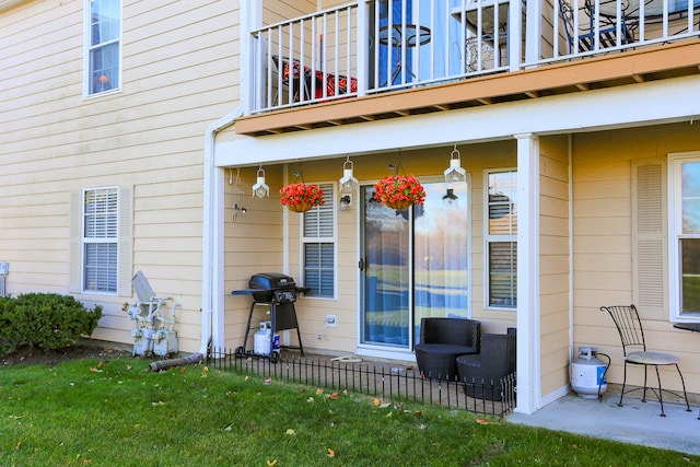 property entrance featuring a lawn and a balcony