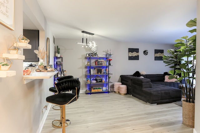 living room with light hardwood / wood-style floors and a notable chandelier