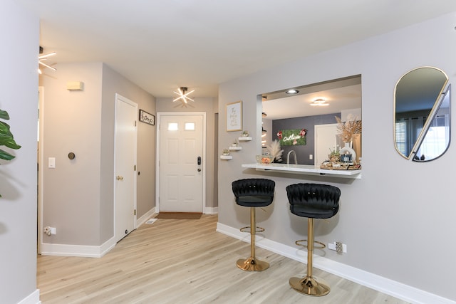 entryway featuring bar and light hardwood / wood-style flooring