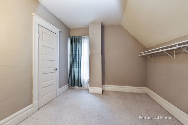 interior space featuring light carpet and vaulted ceiling