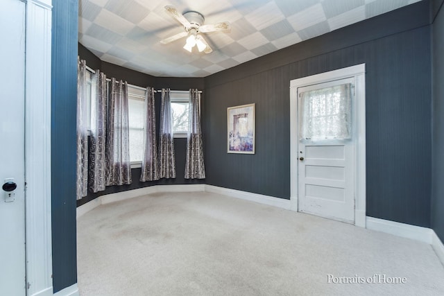 carpeted spare room featuring ceiling fan