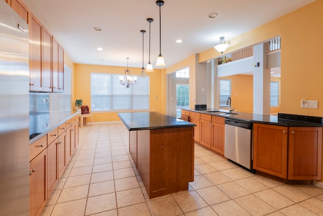 kitchen with pendant lighting, a center island, stainless steel appliances, and dark stone counters