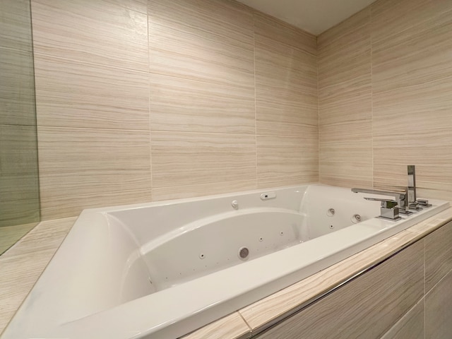 bathroom featuring tiled bath and tile walls