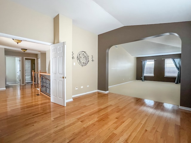 empty room featuring wood-type flooring and lofted ceiling