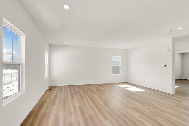 spare room with light wood-style floors, baseboards, and recessed lighting