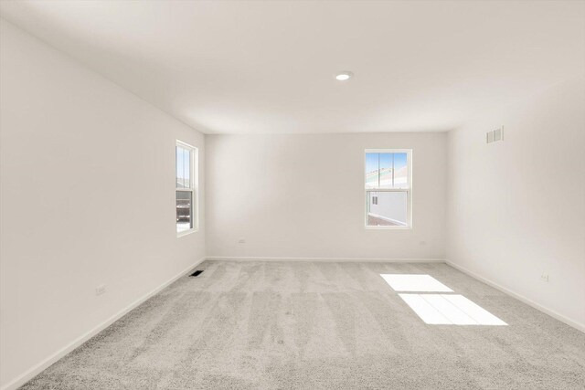 bedroom with ensuite bath, light colored carpet, lofted ceiling, and multiple windows