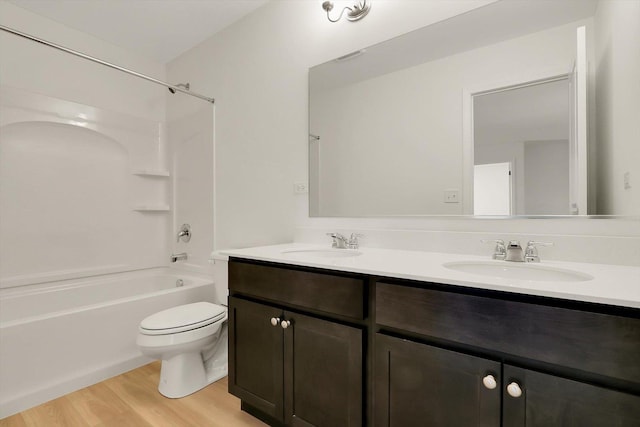 bathroom with shower / washtub combination, a sink, toilet, and wood finished floors