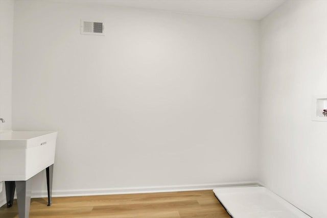 laundry room featuring hookup for a washing machine, laundry area, wood finished floors, visible vents, and baseboards