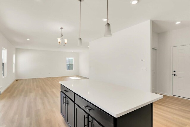 kitchen with pendant lighting, a kitchen island, dark wood-type flooring, and gas range