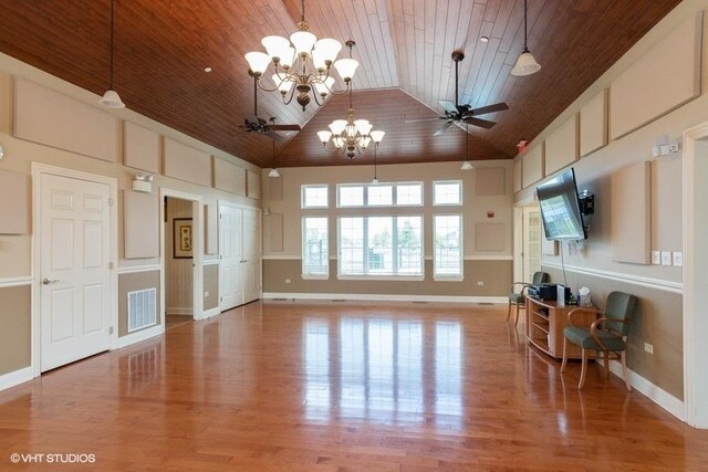 unfurnished living room with hardwood / wood-style flooring, ceiling fan with notable chandelier, wooden ceiling, and high vaulted ceiling