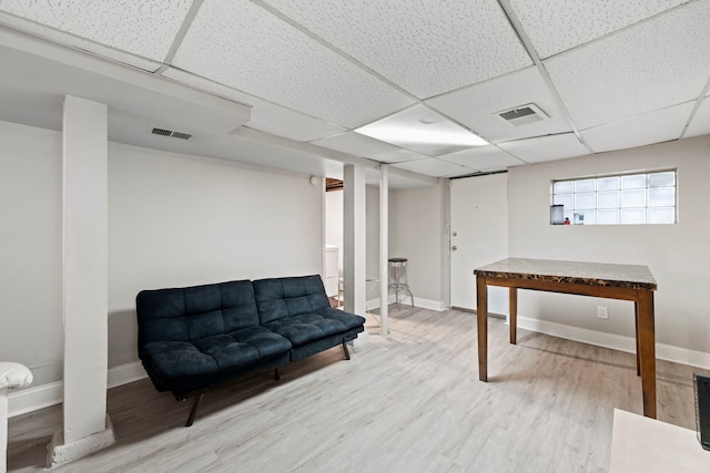 living area with hardwood / wood-style floors and a drop ceiling