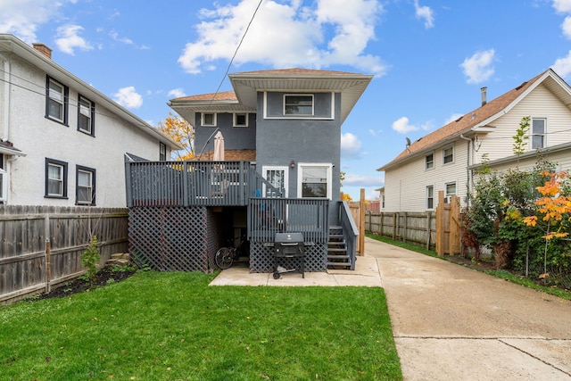 rear view of property with a yard and a deck