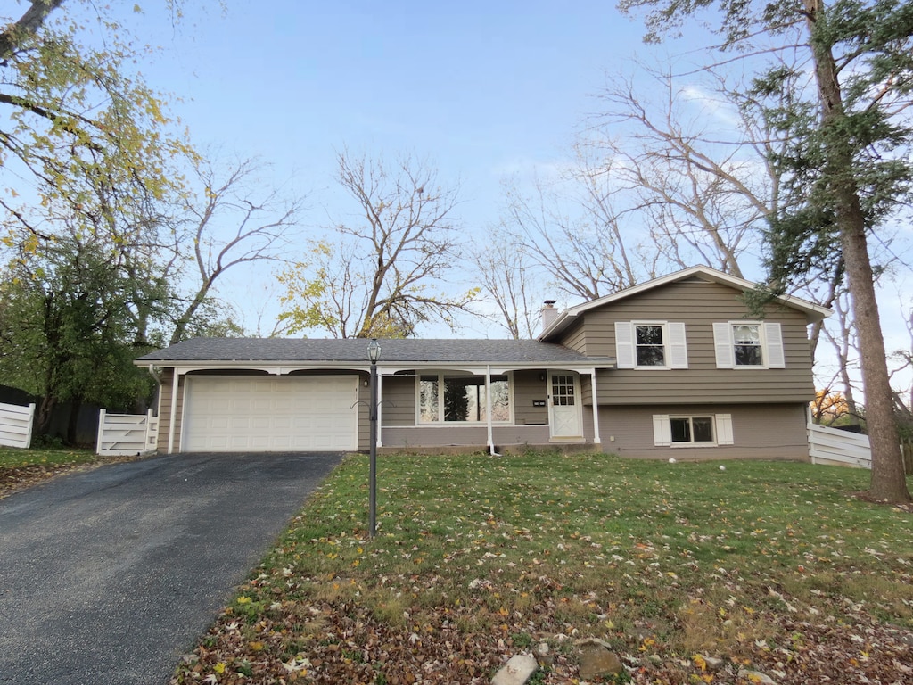 tri-level home featuring a front yard and a garage