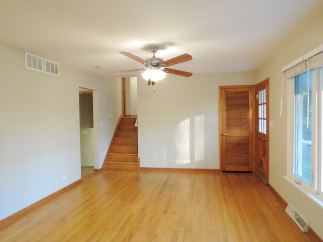 empty room featuring ceiling fan, a healthy amount of sunlight, and light hardwood / wood-style floors