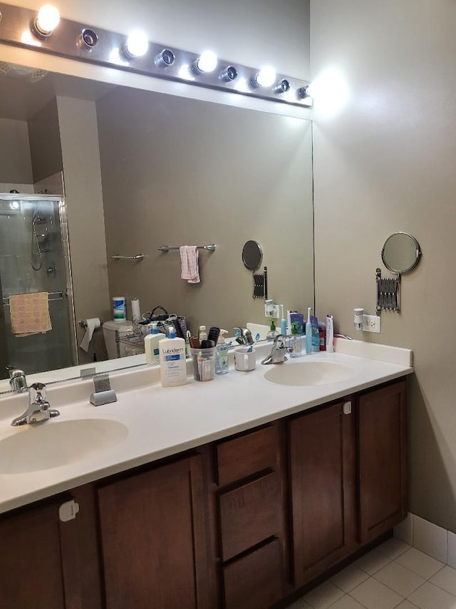 bathroom featuring tile patterned flooring, vanity, toilet, and an enclosed shower