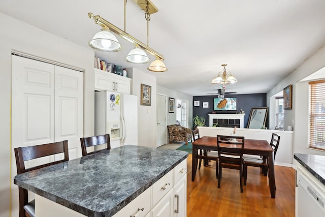 kitchen featuring white appliances, dark hardwood / wood-style floors, white cabinetry, and a kitchen island