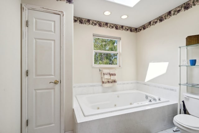 bathroom with tile patterned floors, toilet, and tiled tub