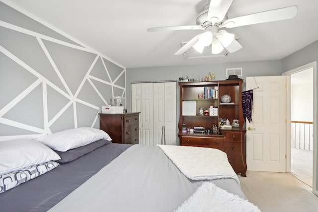 carpeted bedroom featuring ceiling fan and a closet