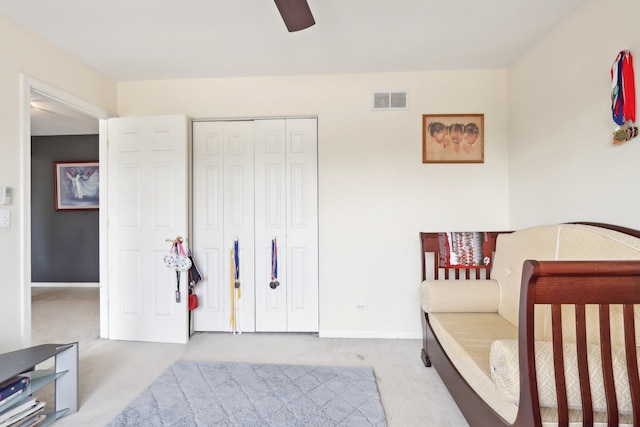 carpeted bedroom featuring a closet and ceiling fan