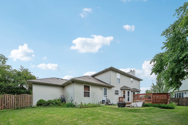 rear view of house with a yard and a wooden deck