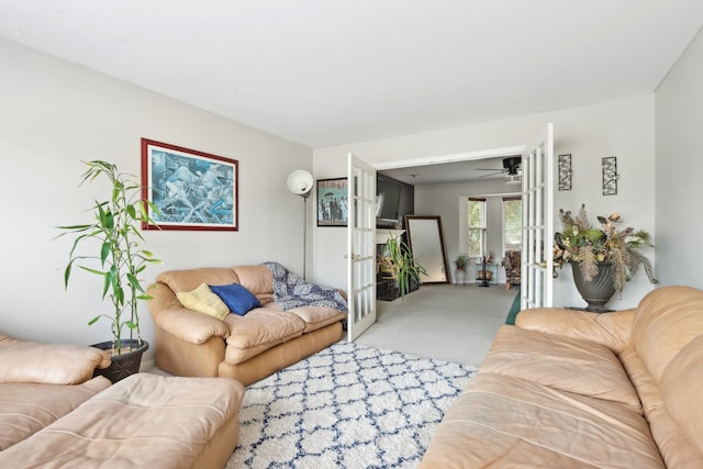 carpeted living room with french doors and ceiling fan