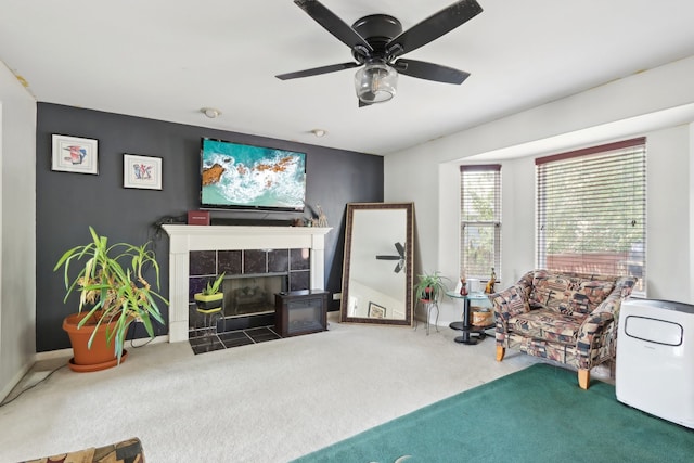 sitting room featuring ceiling fan, carpet floors, and a tile fireplace