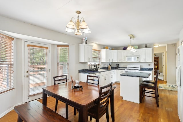 dining area with wood-type flooring, sink, and a chandelier