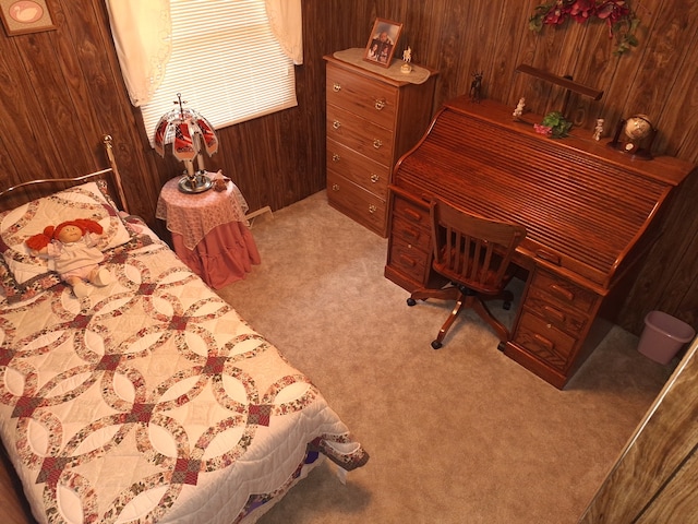 bedroom with wooden walls and light colored carpet