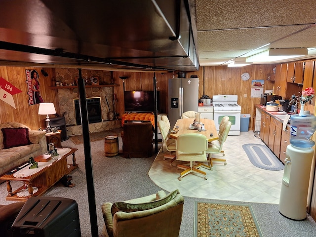 interior space with a stone fireplace, sink, and wooden walls