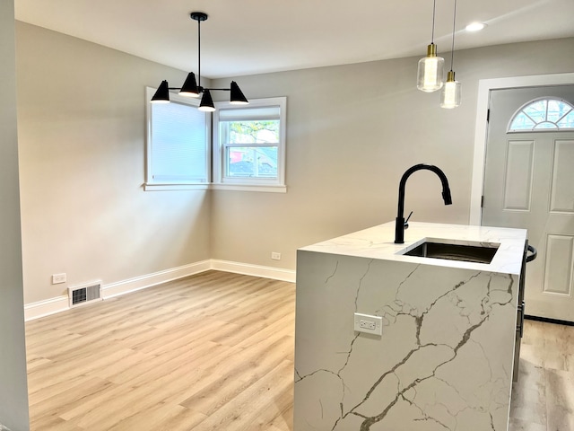 washroom with light hardwood / wood-style flooring, plenty of natural light, and sink