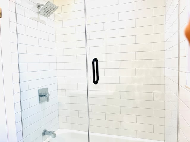 bathroom featuring combined bath / shower with glass door