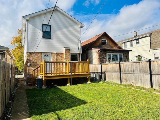 back of property featuring a lawn and a deck