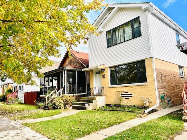 view of front facade featuring a sunroom and a front yard