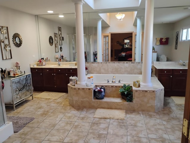 bathroom with tile patterned flooring, vanity, separate shower and tub, and ornate columns