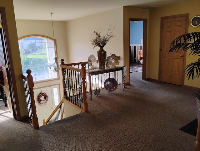 hall featuring carpet flooring and a notable chandelier