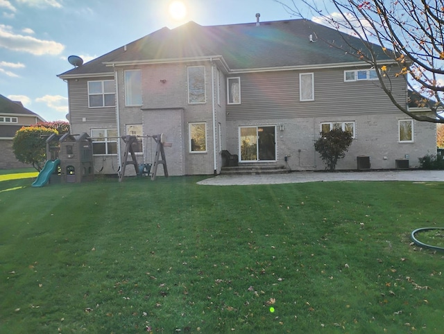 rear view of house featuring a yard and central AC unit