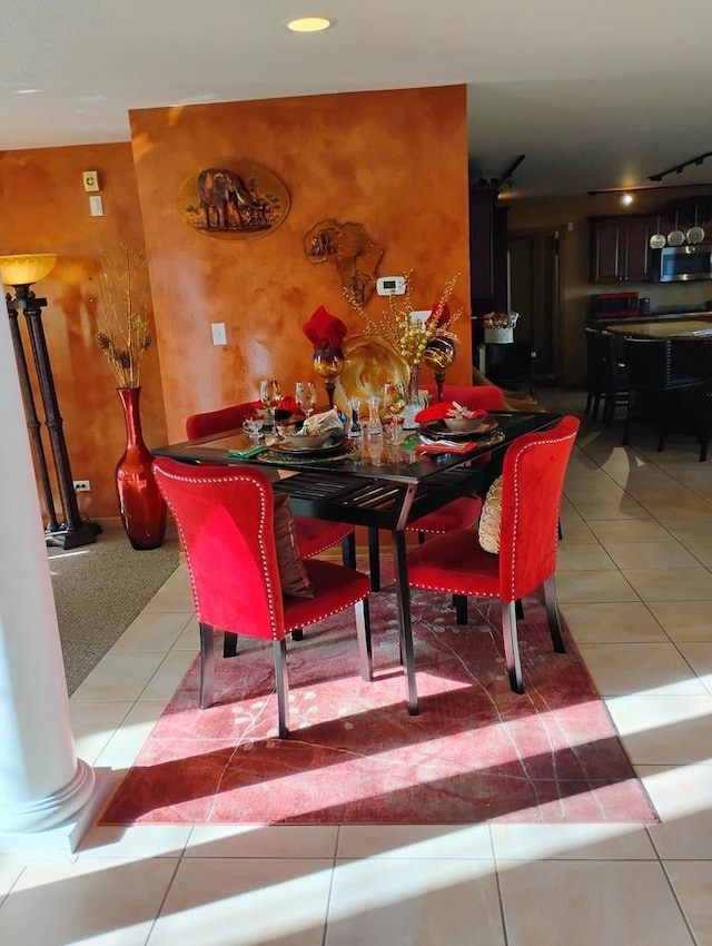 dining room with ornate columns and light tile patterned floors