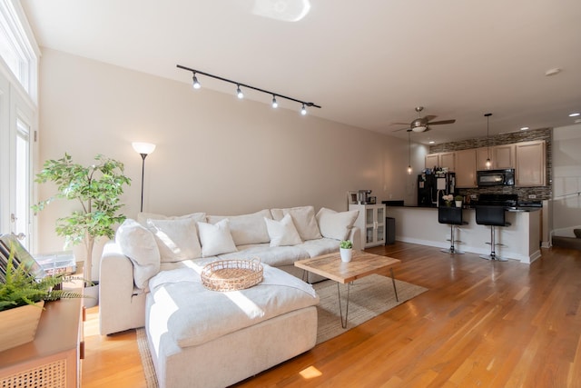 living room with light wood-style flooring and ceiling fan