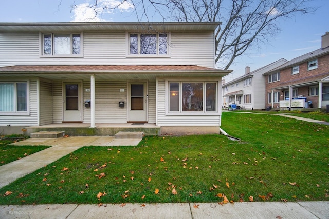 view of front of house with covered porch and a front lawn