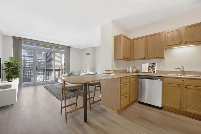 kitchen featuring sink, stainless steel dishwasher, light hardwood / wood-style floors, and kitchen peninsula