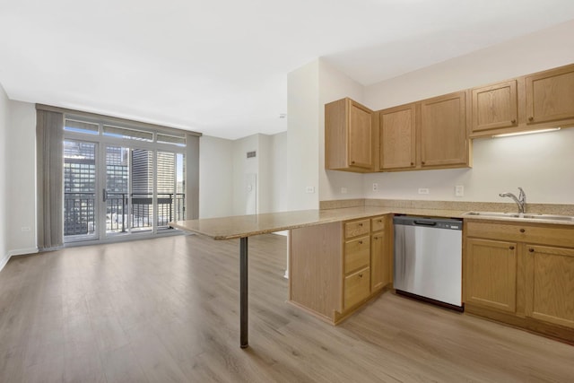 kitchen featuring sink, light hardwood / wood-style flooring, stainless steel dishwasher, kitchen peninsula, and light brown cabinets