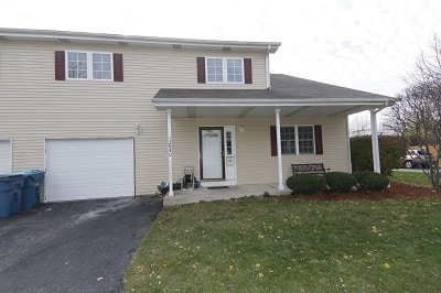 view of front facade featuring a porch, a front yard, and a garage