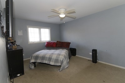 bedroom with ceiling fan and light colored carpet