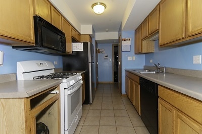 kitchen featuring light tile patterned floors, sink, and black appliances