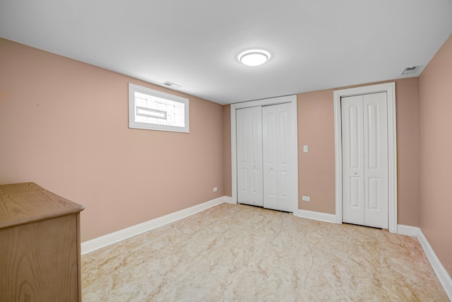 unfurnished bedroom featuring two closets