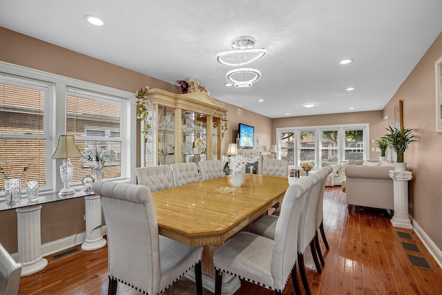 dining room with dark wood-type flooring and an inviting chandelier